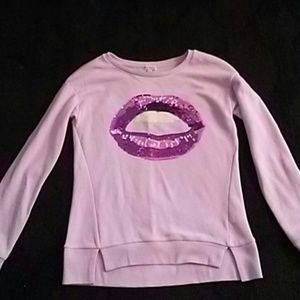 Lavender sweat shirt with big lips in front of shi